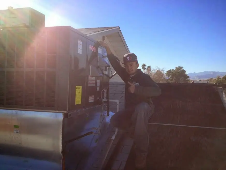 HVAC technician performing AC Tune-Up on a rooftop unit in Westville